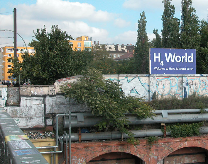 Berlin-Friedrichshain. RAW Tempel: "H4 World, Welcome to Hartz IV-Arena Berlin", Plakat im O2-World-Look. Fun-World im Kontrast zur politisch-sozialen Wirklichkeit 